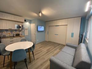 ein Wohnzimmer mit einem Sofa und einem Tisch sowie eine Küche in der Unterkunft Sendy Home Roccaraso 2 in Roccaraso
