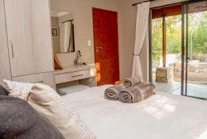 una camera da letto con un letto e asciugamani di Sweni Lodge 91 Mjejane Kruger Park a Hectorspruit