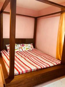 a bed with a wooden frame in a bedroom at Luzville Residences - C8 in Naic