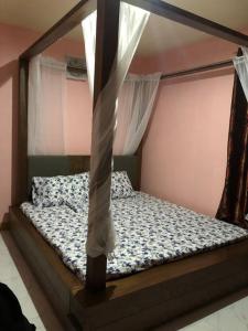 a bed with a canopy in a bedroom at Luzville Residences - C8 in Naic