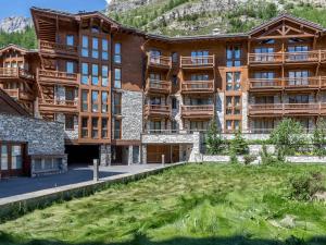 ein großes Gebäude mit einem Rasenplatz davor in der Unterkunft Magnifique Appartement au Centre de Val-d'Isère, Proche Pistes et Commerces - FR-1-519-1 in Val dʼIsère