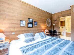 ein Schlafzimmer mit einem Bett und einer Holzwand in der Unterkunft Magnifique Appartement au Centre de Val-d'Isère, Proche Pistes et Commerces - FR-1-519-1 in Val dʼIsère
