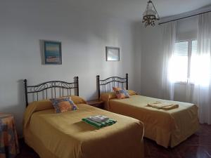twee bedden in een kamer met gele lakens bij Casa Ana in Algodonales
