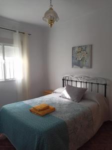 een slaapkamer met een bed met twee handdoeken erop bij Casa Ana in Algodonales