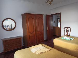 een slaapkamer met 2 bedden, een kast en een spiegel bij Casa Ana in Algodonales