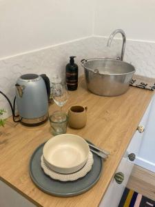 a counter top with plates and a bowl and a sink at Blue Heart Studio Apartment in Willunga