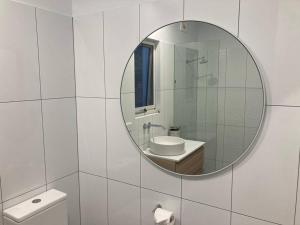 a bathroom with a mirror and a sink and a toilet at Blue Heart Studio Apartment in Willunga