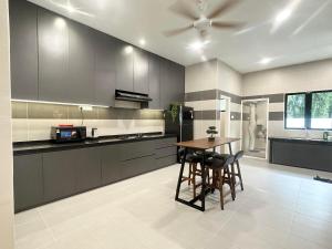 a kitchen with a table and a ceiling fan at 《Untitled HomeStay》Sitiawan in Sitiawan