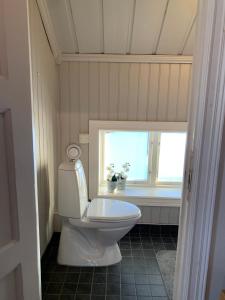 um WC branco numa casa de banho com uma janela em Proselinsgården em Bjursås