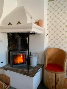 a fireplace in a room with a chair and a stove at Proselinsgården in Bjursås