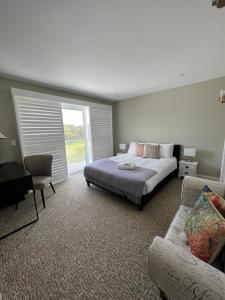 1 dormitorio con cama, sofá y ventana en Beach House at Hargraves, en Norah