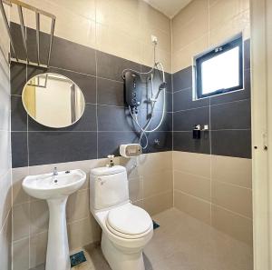 La salle de bains est pourvue de toilettes, d'un lavabo et d'un miroir. dans l'établissement 《Untitled HomeStay》Sitiawan, à Sitiawan