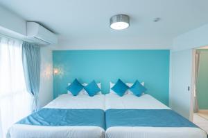 1 dormitorio azul con 1 cama grande con almohadas azules en Fuchsia - Vacation STAY 08005v en Nagoya