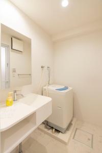 a white bathroom with a toilet and a sink at Fuchsia - Vacation STAY 08005v in Nagoya