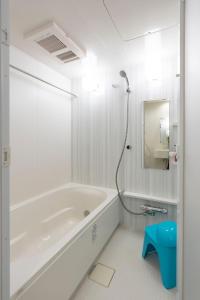 a white bathroom with a tub and a mirror at Fuchsia - Vacation STAY 08005v in Nagoya