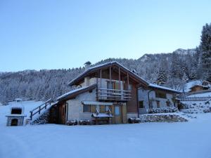 a log cabin in the snow with snow covered trees at Delightful hut with spectacular views of the Pale di San Martino in Tonadico