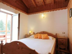 a bedroom with a bed and a large window at Delightful hut with spectacular views of the Pale di San Martino in Tonadico