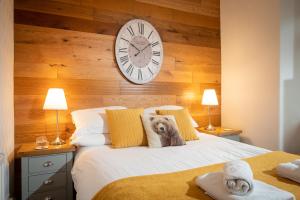 a bedroom with a clock on the wall and a bed at Woodland Cottage - cosy dog friendly cottage in the heart of Windermere in Windermere
