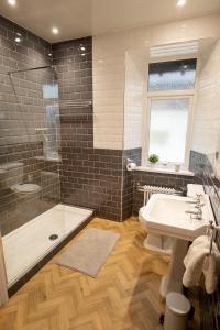 a bathroom with a tub and a sink and a shower at Woodland Cottage - cosy dog friendly cottage in the heart of Windermere in Windermere