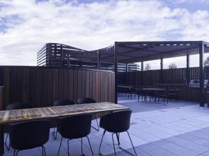 a patio with a wooden table and chairs on a deck at Skyone Lux 2Bed room Aprt in BoxHill with car park in Box Hill
