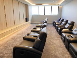 a row of leather chairs in a waiting room at Skyone Lux 2Bed room Aprt in BoxHill with car park in Box Hill