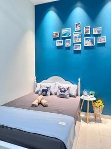 a bedroom with a bed with a blue wall at The Blue Memories Homestay (Mediterranean Style) in Sungai Pelik