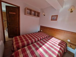 オルシエールにあるAppartement au Chalet d'Orcières Merletteの小さなベッドルーム(ベッド1台、プライド毛布付)