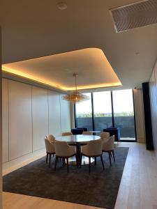 a dining room with a table and chairs and a chandelier at Skyone Lux 2Bed room Aprt in BoxHill with car park in Box Hill