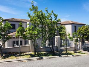 una valla frente a una casa con árboles en Harbour Close Boutique Villa en Ciudad del Cabo