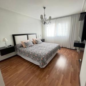 1 dormitorio con 1 cama y suelo de madera en Dpto Plaza Mitre con Cochera en Mar del Plata