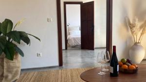 a room with a table with wine glasses and a bedroom at Casa Moni con Vistas al Mar in Playa de Santiago