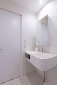 a white bathroom with a sink and a mirror at Fuchsia - Vacation STAY 20104v in Nagoya