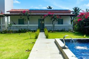 a house with a swimming pool in the yard at Barra Beach House in Fortim
