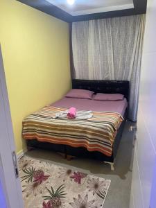 Un dormitorio con una cama con un sombrero rosa. en İmperyum park vilları en Çiftlikköy
