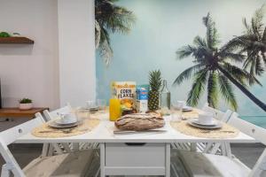 a table with a breakfast of bread and orange juice at Apartamento cerca del mar, del puerto y del centro in Valencia