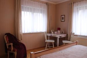 a bedroom with a table and chairs and a bed at Ferienwohnung Felicitas Wilthen in Wilthen