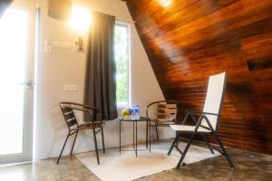 a dining room with a table and chairs and a wooden wall at Durian Ecolodge in Tampin