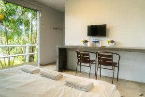 Zimmer mit einem Bett mit zwei Stühlen und einer Theke in der Unterkunft Durian Ecolodge in Tampin