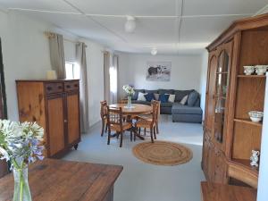una sala de estar con una mesa y un sofá en De Hoop Guest Farm, en Beaufort West