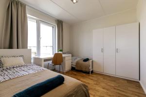 Schlafzimmer mit einem Bett, einem Schreibtisch und einem Fenster in der Unterkunft Tallinn Residences in Petrikyula