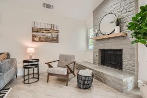 a living room with a stone fireplace and a chair at Cozy Stylish Home in Round Rock! in Round Rock
