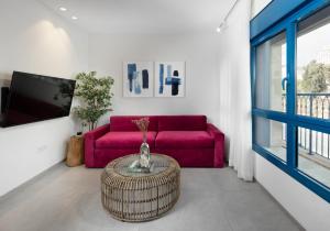 a living room with a pink couch and a table at AMALON Boutique Apartments in Jerusalem