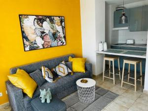 Una sala de estar con un sofá y una cocina. en Casa Clara - Playa Matagorda, en Puerto del Carmen