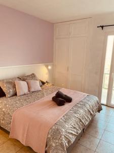 een slaapkamer met een bed met een roze deken bij Casa Clara - Playa Matagorda in Puerto del Carmen