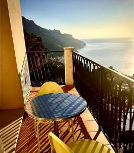 una mesa y sillas en un balcón con vistas al océano en La Dolce Vita Ravello, en Ravello