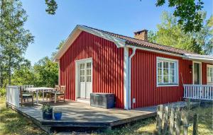 a red house with a deck and a table at Gorgeous Home In lem With Wifi in Ålem