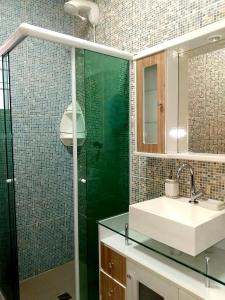 La salle de bains est pourvue d'un lavabo et d'une douche en verre. dans l'établissement Chácara de Temporada - Mairiporã, à Mairiporã