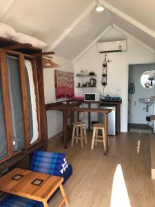 a living room with a table and a kitchen at Walden Koh Lanta - Tiny Homes by the Sea in Ko Lanta