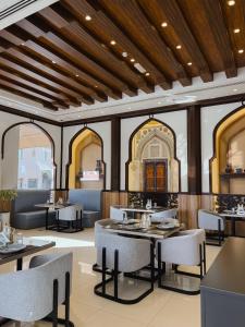 マスカットにあるAl Maha Int Hotel Omanの天井のレストラン(テーブル、椅子付)