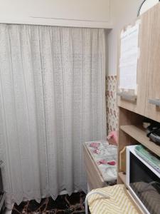 錫蒂亞的住宿－Nepheli，一间设有白色窗帘和桌子的房间